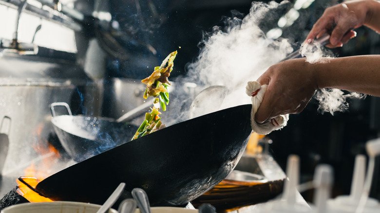 Stir fry in a wok in a restaurant kitchen.