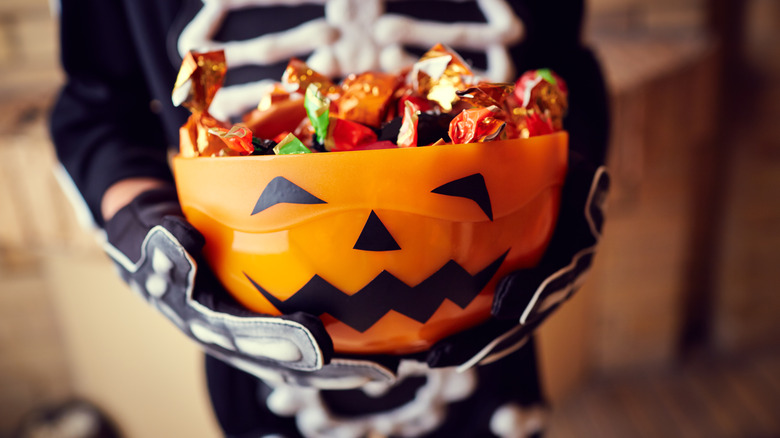 Child holding bowl Halloween candy