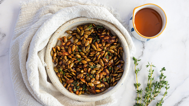 Maple seeds in white bowl with napkin, thyme and maple syrup