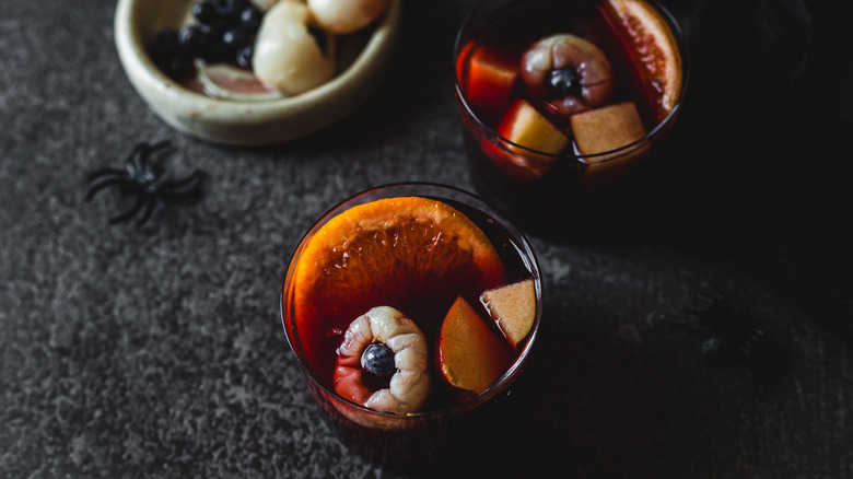 Two sangria glasses with litchi eyeballs and spider