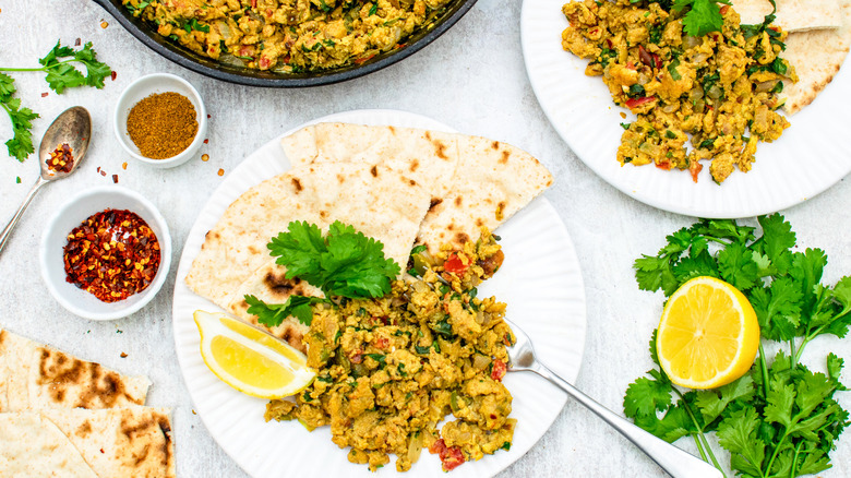 Masala egg bhurji on plate with chapati and lemon