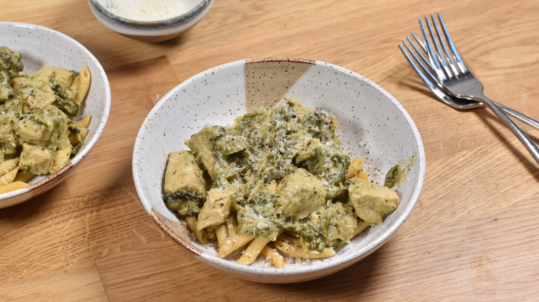 spinach artichoke pasta with chicken in bowls