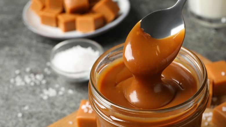 Caramel on spoon in jar