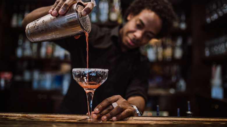 bartender filling drink at bar