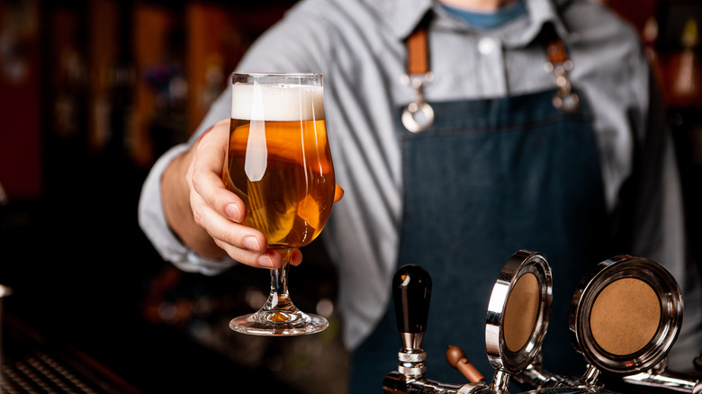 Bartender passing beer to a patron