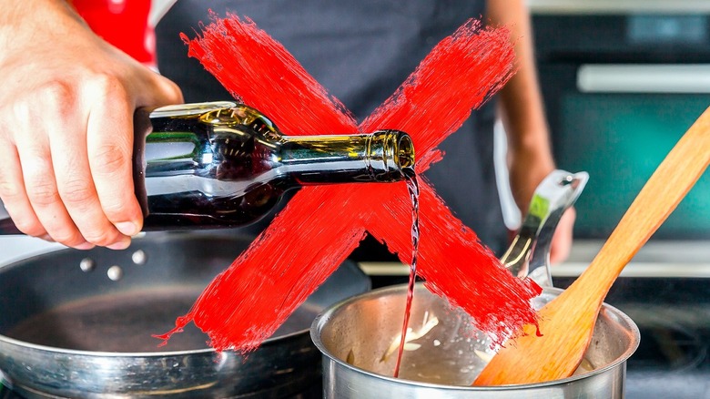 person pouring wine into pan