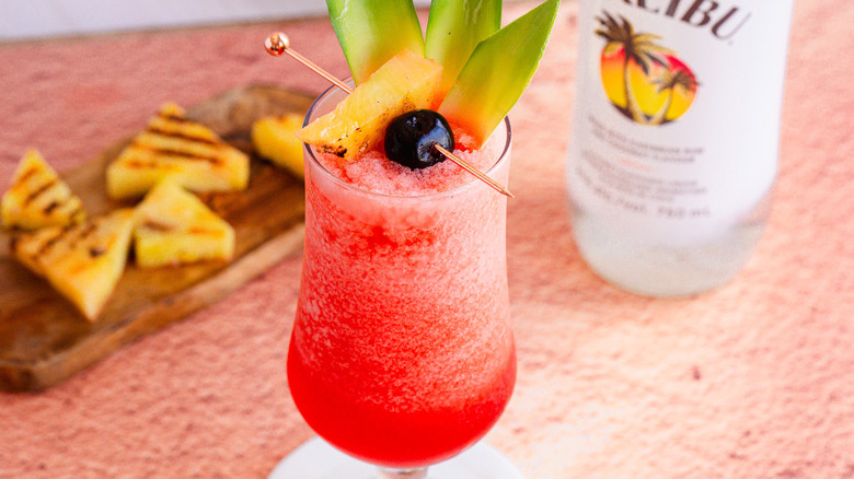 Frozen cocktail with garnish and charred pineapple in background