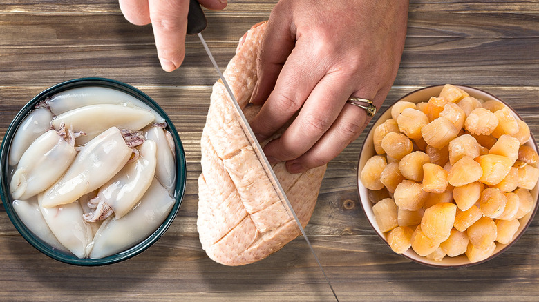 cook scoring squid, duck, and scallops