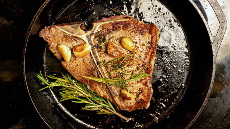 steak cooking in cast iron skillet