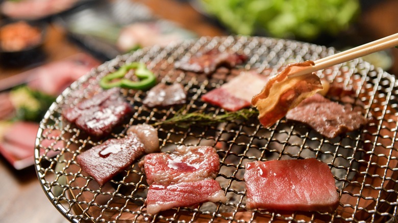 cuts of beef grilling on a yakiniku grill