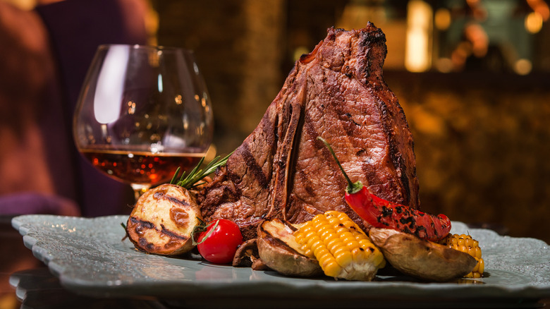 whiskey glass next to grilled t-bone steak